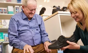 goed-medewerker helpt man schoenen passen